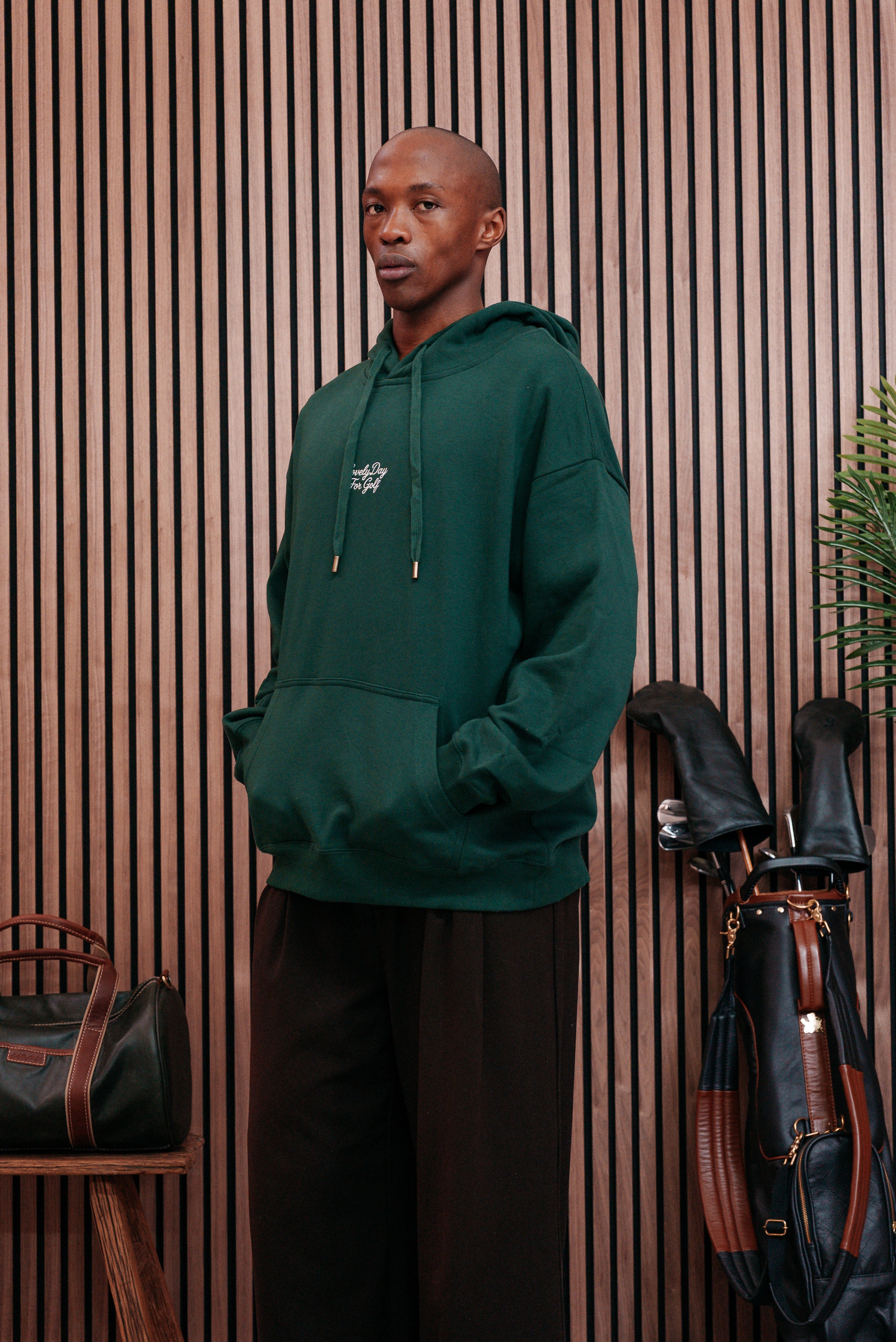 Forest green hoodie worn with hands in the kangaroo pocket