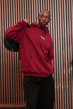 Burgundy hoodie with the hood pulled up